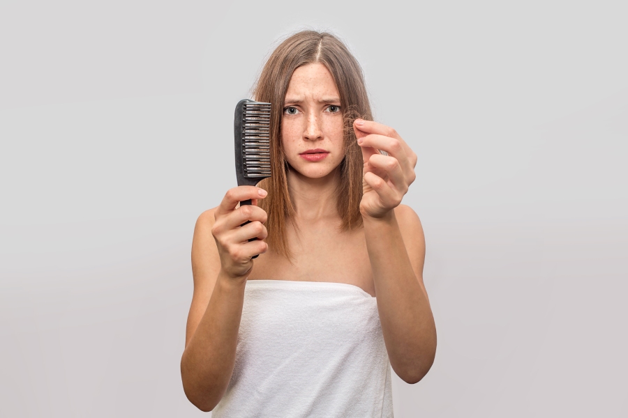 Worried young woman because of hair loss